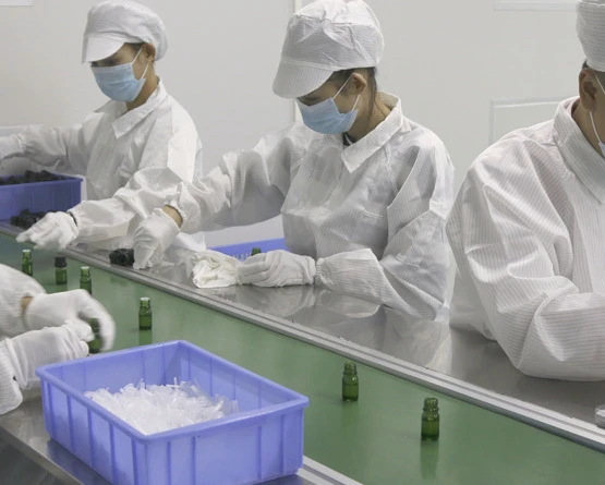 Gloved staff handling small components at a worktable